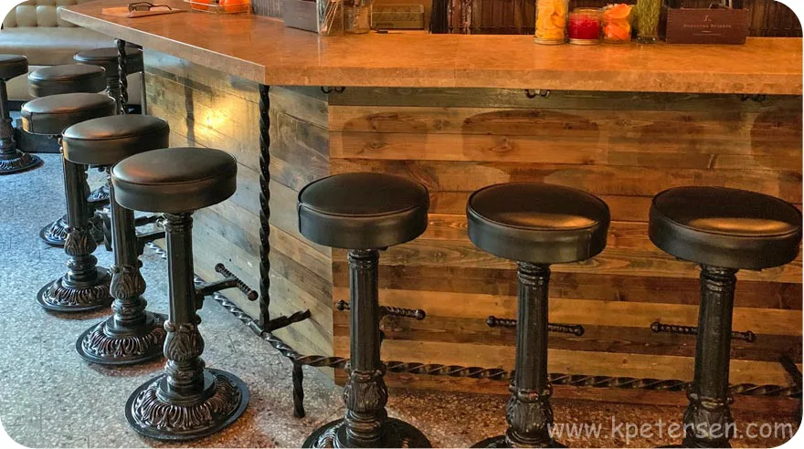 Speakeasy Bar Front With Ornate Cast Iron Round Bottom Pub Stools